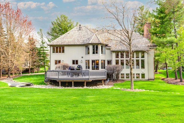 318 Camelot Ln, Libertyville, IL 60048 - rear view of house featuring a chimney, a wooden deck, and a lawn