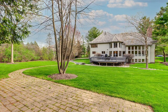 back of house with a lawn, a wooden deck, a chimney, and outdoor dining space