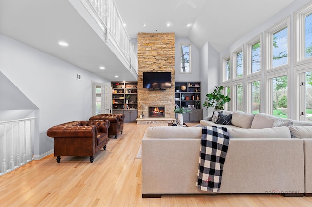 318 Camelot Ln, Libertyville, IL 60048 - living area with high vaulted ceiling, light wood-style flooring, a stone fireplace, baseboards, and recessed lighting