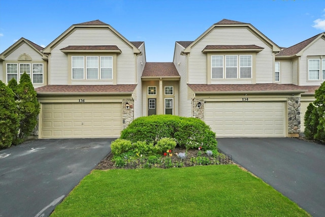view of front of property with an attached garage, driveway, and stone siding