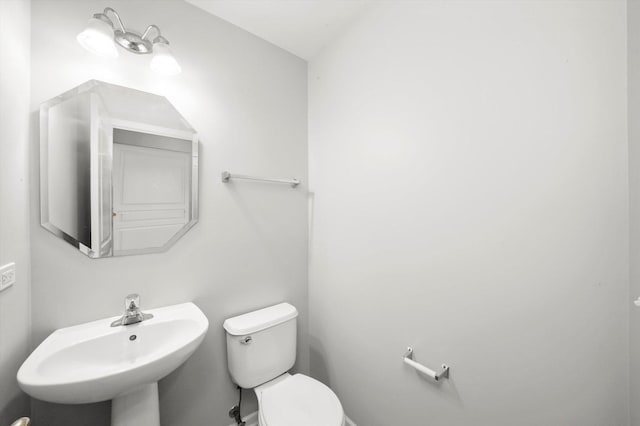 half bathroom featuring a sink and toilet