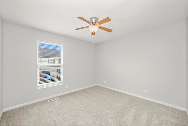 spare room with light carpet, baseboards, and ceiling fan