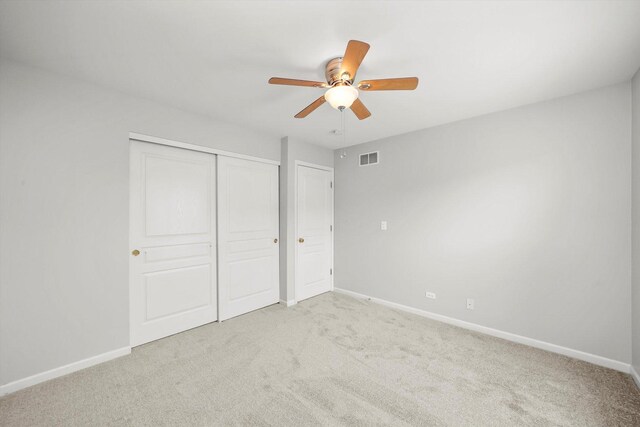 unfurnished bedroom with light carpet, a closet, and baseboards