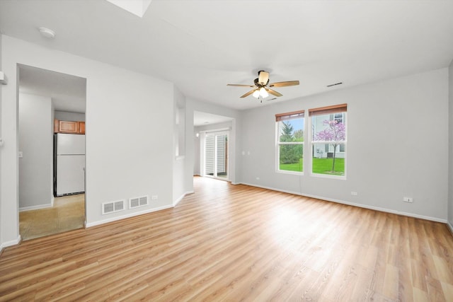 unfurnished living room with baseboards, light wood-type flooring, and a ceiling fan