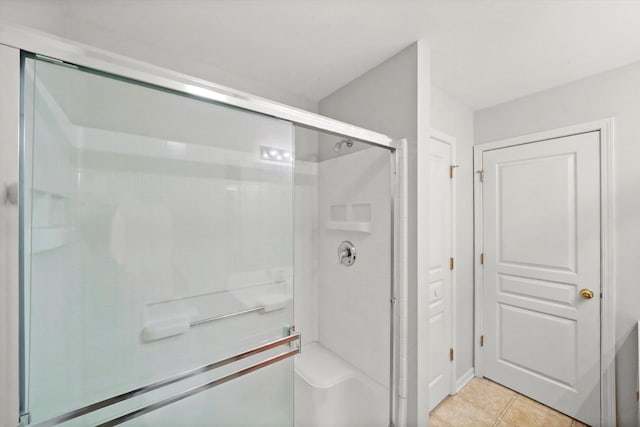 full bath with a shower stall and tile patterned floors