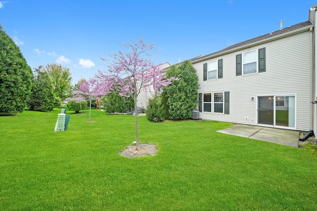 view of green lawn featuring central air condition unit and a patio area