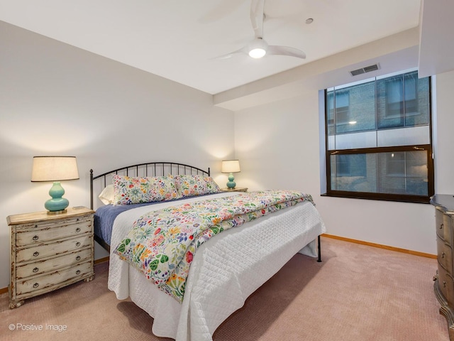 carpeted bedroom with visible vents, baseboards, and a ceiling fan