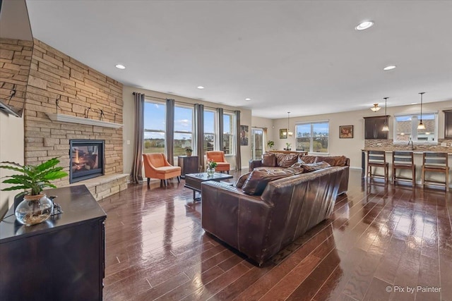 living room with a fireplace, recessed lighting, and dark wood-type flooring