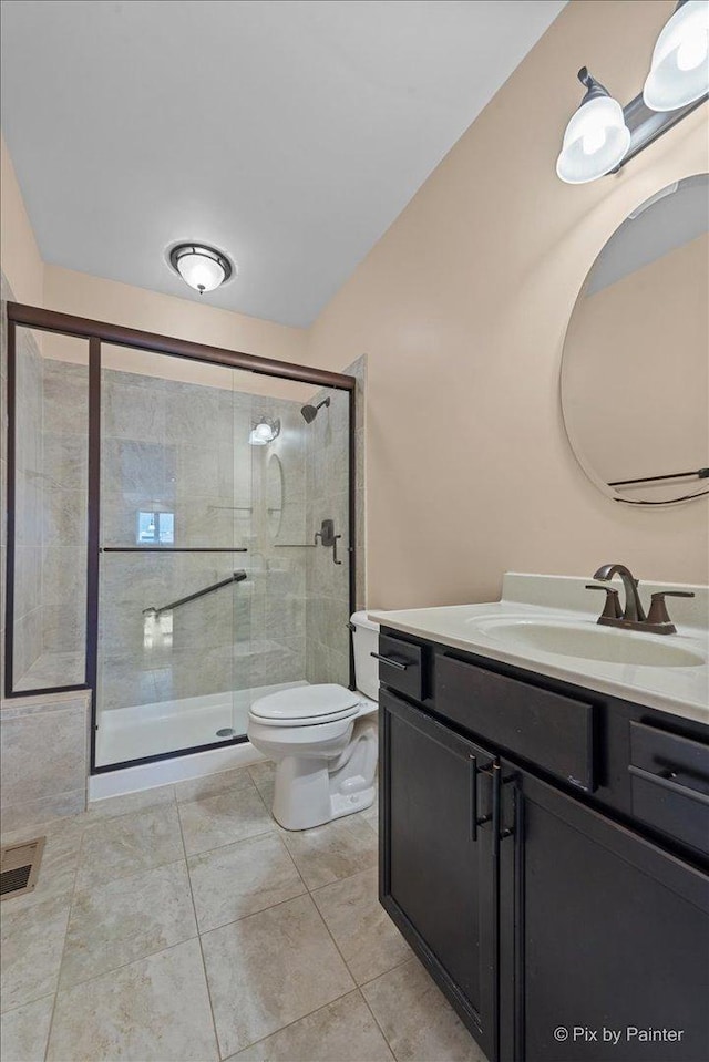 full bath featuring vanity, tile patterned floors, a shower stall, and toilet