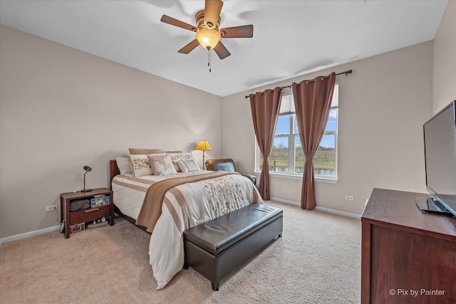 bedroom featuring baseboards, light carpet, and a ceiling fan