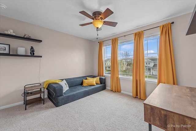 sitting room with carpet floors, a ceiling fan, and baseboards