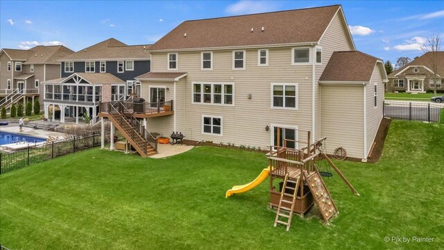 rear view of property featuring fence, a lawn, a playground, and stairway