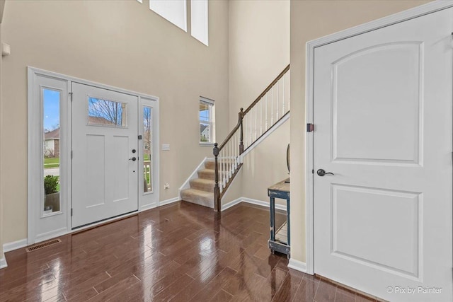 foyer with baseboards, plenty of natural light, stairs, and visible vents
