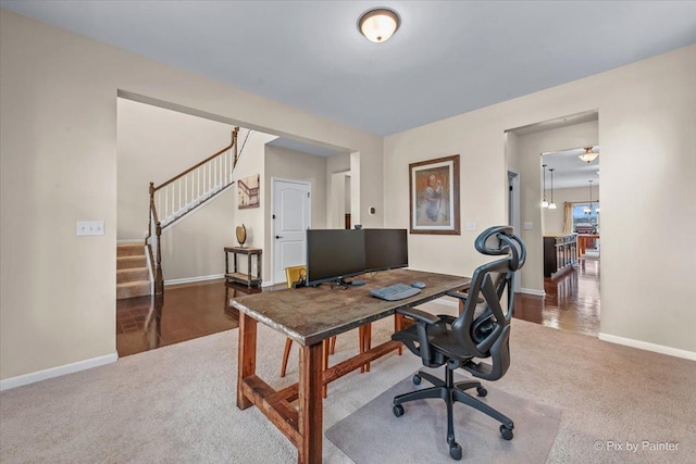 carpeted office space featuring baseboards