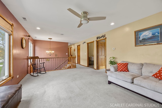 living room with carpet floors, recessed lighting, visible vents, and ceiling fan with notable chandelier