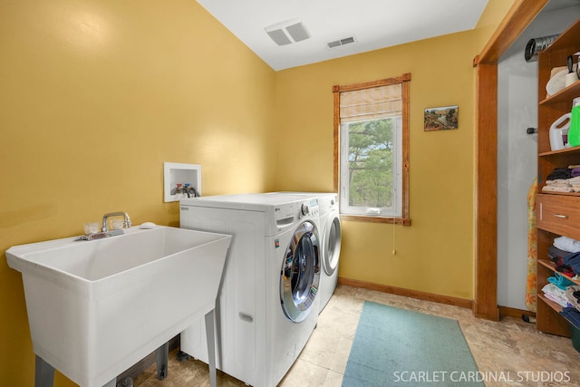 laundry area featuring washer and dryer, laundry area, a sink, baseboards, and visible vents