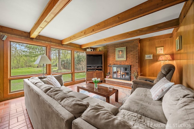 living room featuring wooden walls, a fireplace, and a wealth of natural light