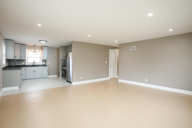 412 N Center Ave, Bradley, IL 60915 - unfurnished living room with visible vents, baseboards, a sink, recessed lighting, and light wood-style flooring