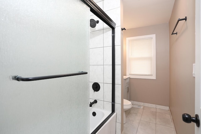412 N Center Ave, Bradley, IL 60915 - full bathroom featuring toilet, tile patterned flooring, baseboards, and bath / shower combo with glass door
