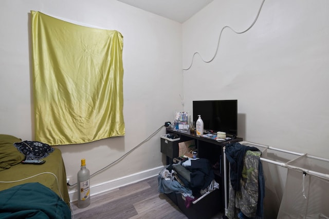 bedroom with baseboards and wood finished floors