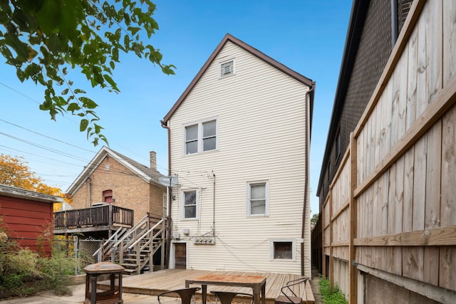 rear view of property with a deck and fence
