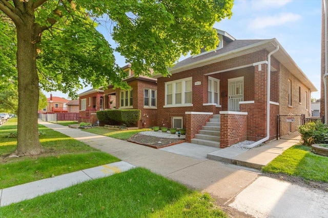 7614 S Chappel Ave, Chicago, IL 60649 - bungalow with brick siding, a front lawn, and fence