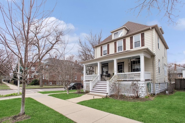 traditional style home with a front yard, a porch, and roof with shingles