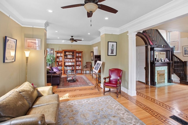 living area featuring ornamental molding, a ceiling fan, a high end fireplace, recessed lighting, and wood finished floors
