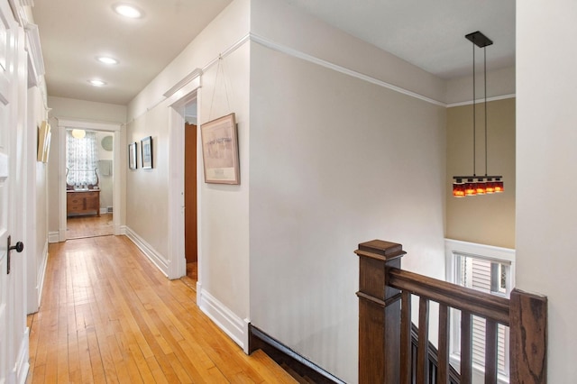 hall featuring recessed lighting, baseboards, an upstairs landing, and light wood-style floors