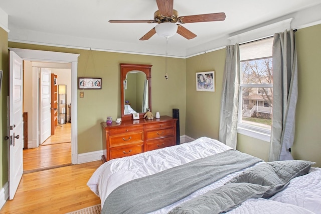 bedroom featuring ceiling fan, light wood finished floors, and baseboards