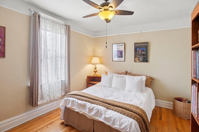 bedroom with baseboards, light wood finished floors, and ceiling fan