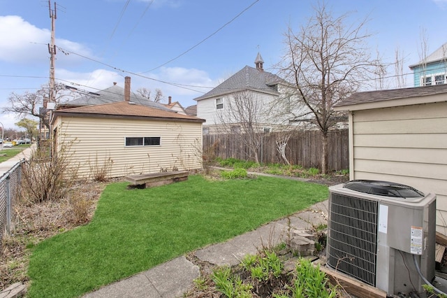 view of yard with central AC, fence private yard, and an outbuilding