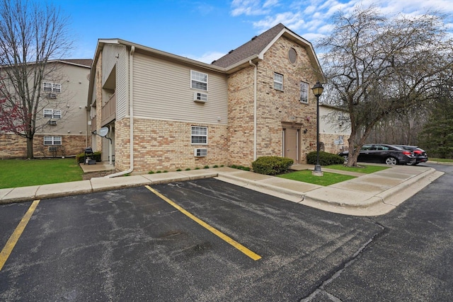 1520 W Sand Bar Ct Unit 1B, Round Lake Beach, IL 60073 - view of side of home featuring brick siding and uncovered parking