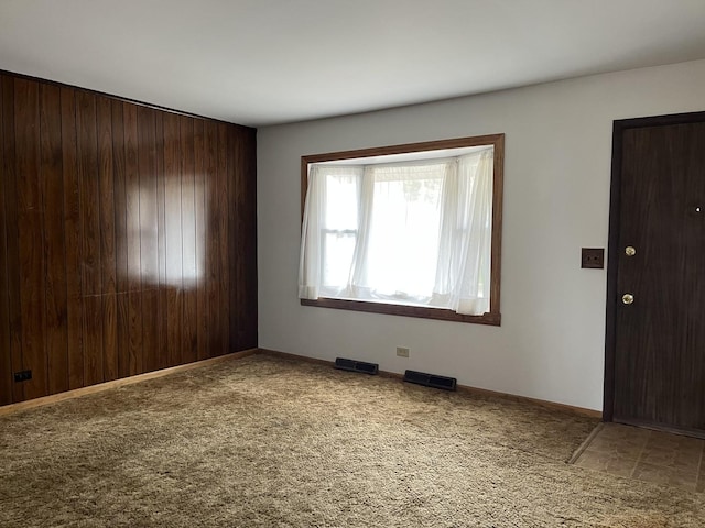 spare room featuring baseboards, visible vents, and carpet floors
