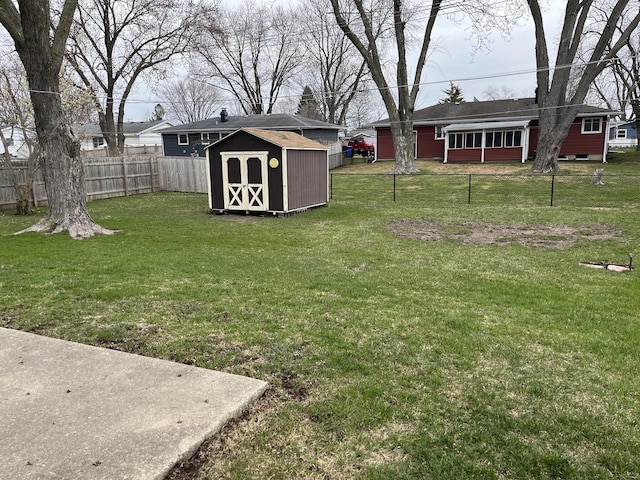 view of yard with a storage shed, a fenced backyard, and an outdoor structure