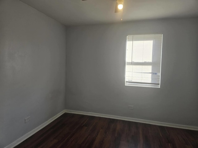 unfurnished room with baseboards, ceiling fan, and dark wood finished floors