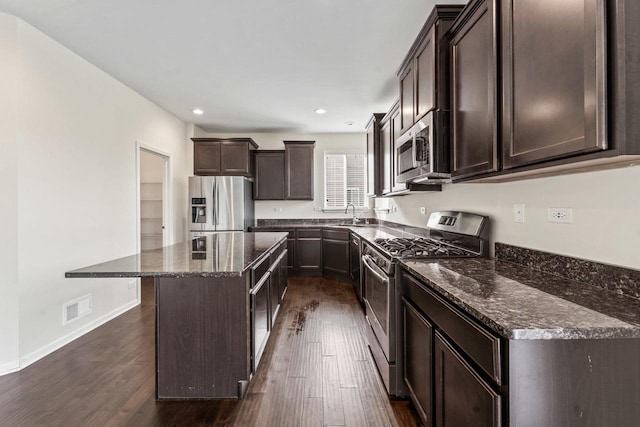 282 Willington Way, Oswego, IL 60543 - kitchen featuring stainless steel appliances, dark brown cabinets, dark stone countertops, dark wood-type flooring, and recessed lighting
