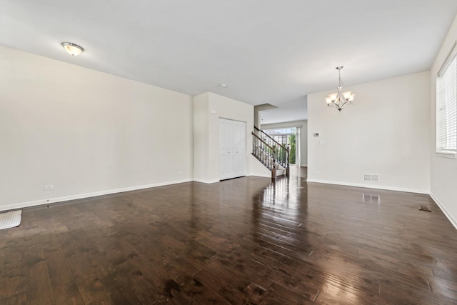 282 Willington Way, Oswego, IL 60543 - spare room featuring a chandelier, dark wood-type flooring, stairway, and baseboards