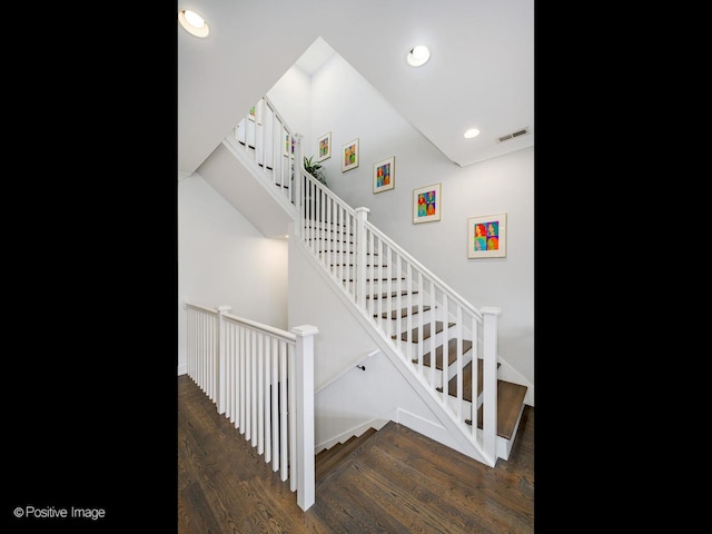 stairs with wood finished floors and recessed lighting