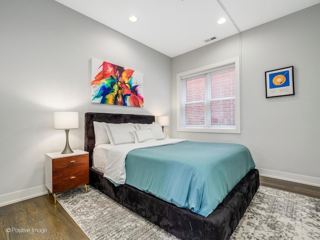 bedroom featuring wood finished floors, baseboards, and recessed lighting