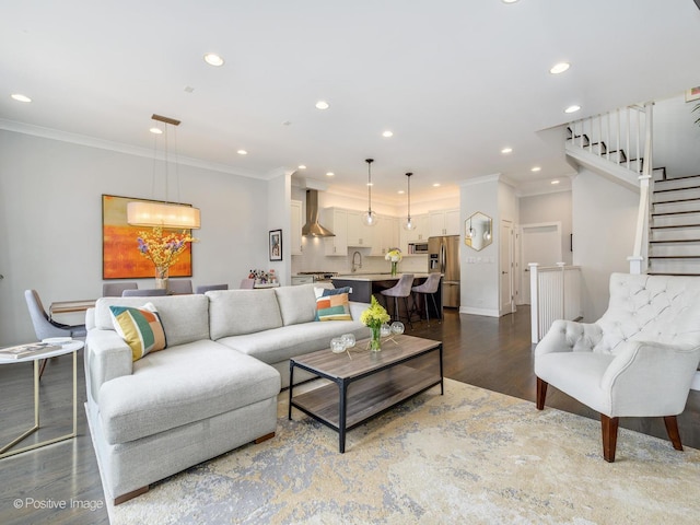 living room featuring wood finished floors, recessed lighting, ornamental molding, stairway, and a chandelier