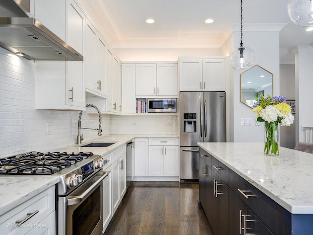 kitchen with stainless steel appliances, wall chimney range hood, a sink, dark wood finished floors, and white cabinets