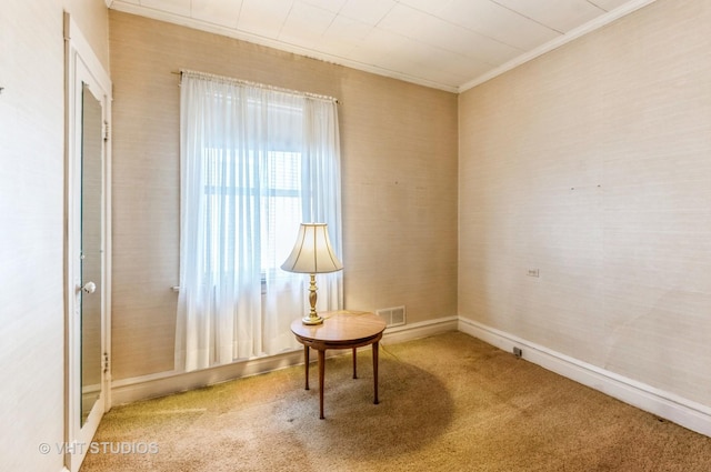living area with crown molding, visible vents, and carpet