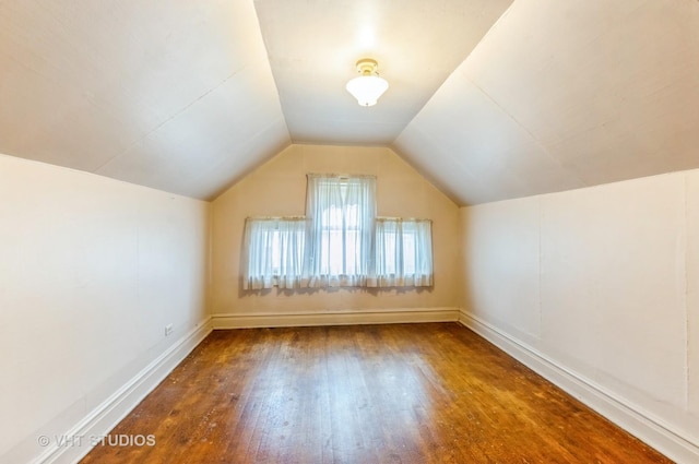 bonus room with vaulted ceiling, wood finished floors, and baseboards