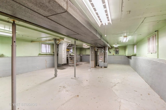 below grade area featuring heating unit and electric panel