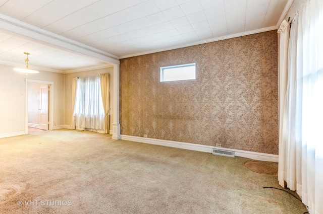 unfurnished room with baseboards, visible vents, wallpapered walls, crown molding, and carpet floors