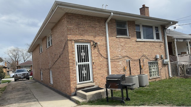 392 Luella Ave, Calumet City, IL 60409 - view of side of home featuring cooling unit, entry steps, a chimney, and brick siding