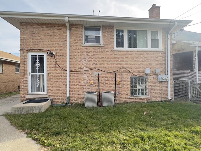 392 Luella Ave, Calumet City, IL 60409 - back of house with fence, a yard, brick siding, and a chimney