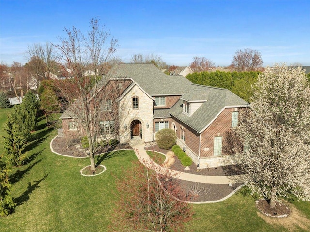 view of front of home featuring a shingled roof and a front lawn