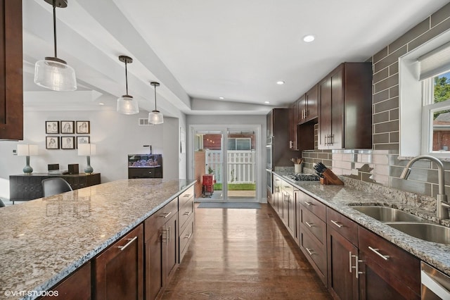 kitchen featuring appliances with stainless steel finishes, light stone countertops, dark wood finished floors, a sink, and recessed lighting
